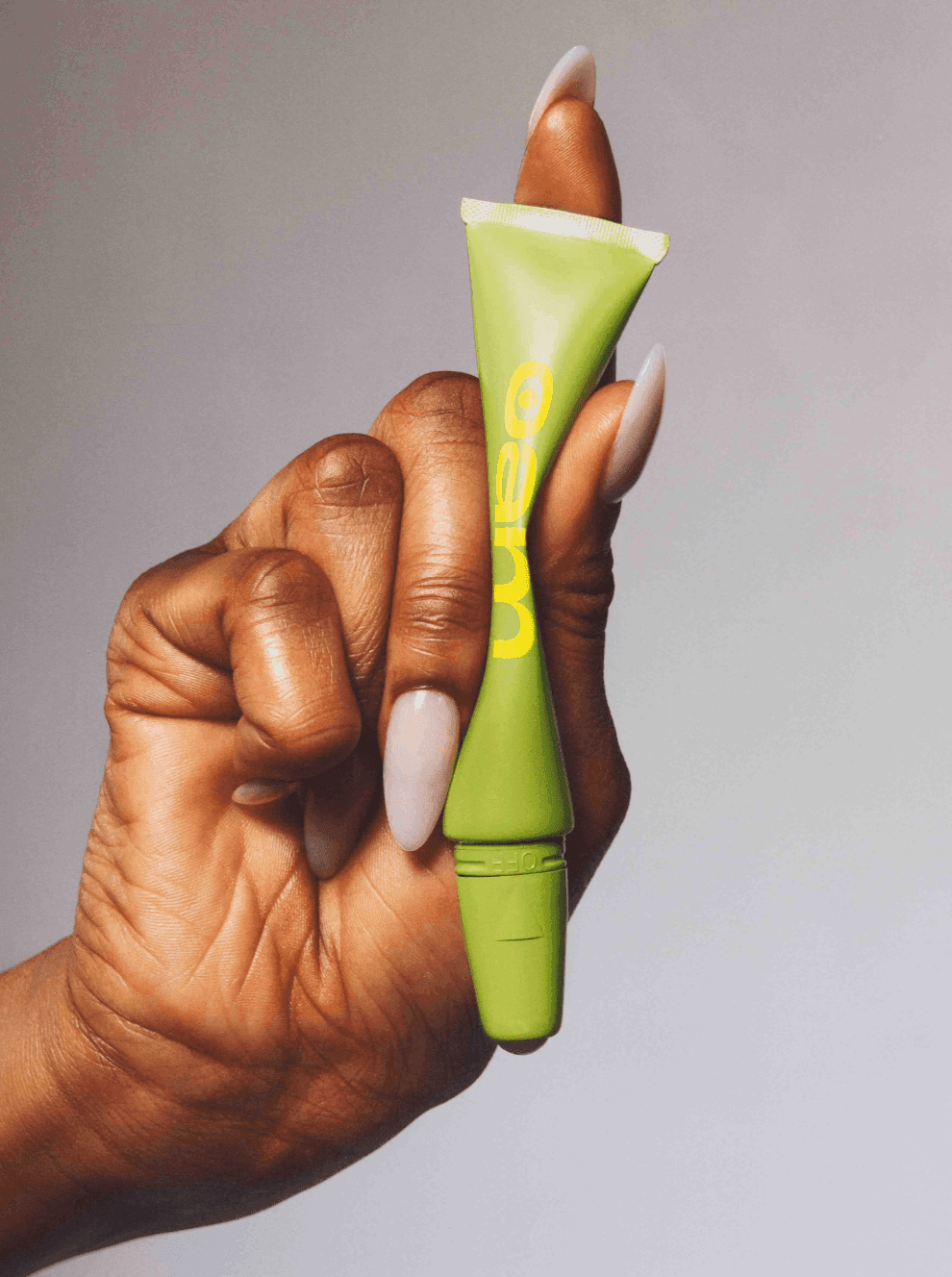 Female hand squeezing the green roller downward.