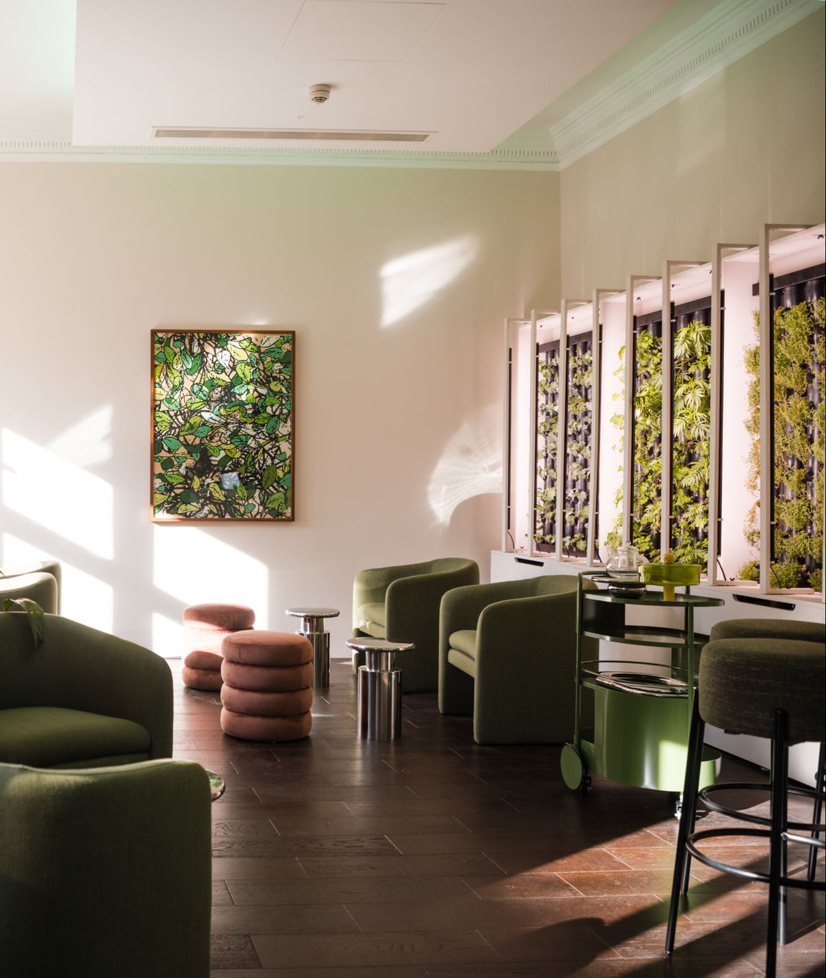 The hydroponic cafe at eyeam world: sage armchairs, a living plant wall and afternoon light through tall windows