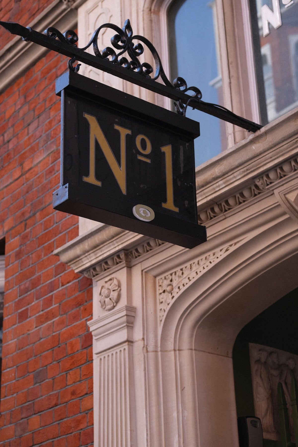 The No 1 hanging sign above the carved stone entrance to 1 Cadogan Gardens, Chelsea