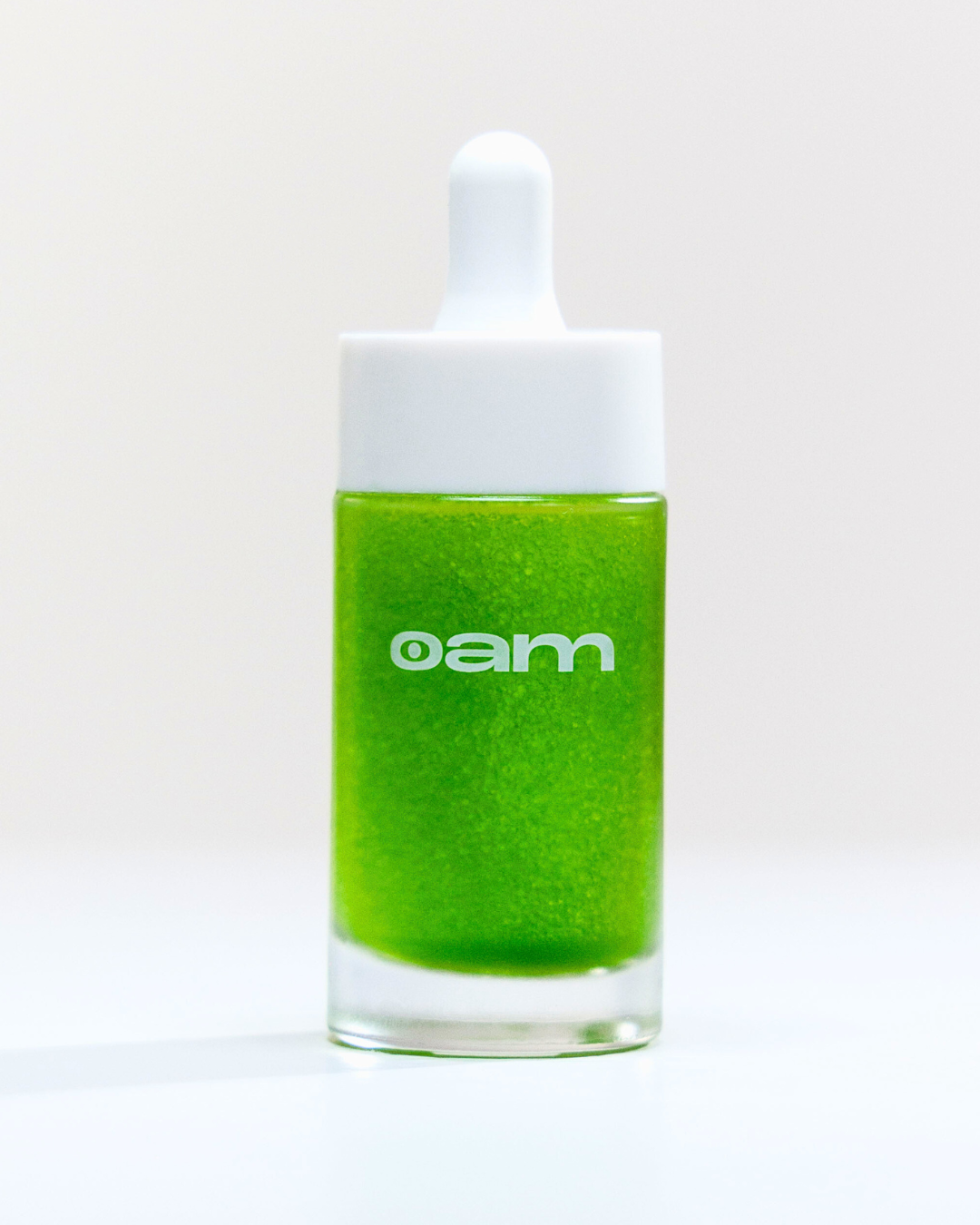 Close up of eyeam dropper. It has a white top and is green inside.
