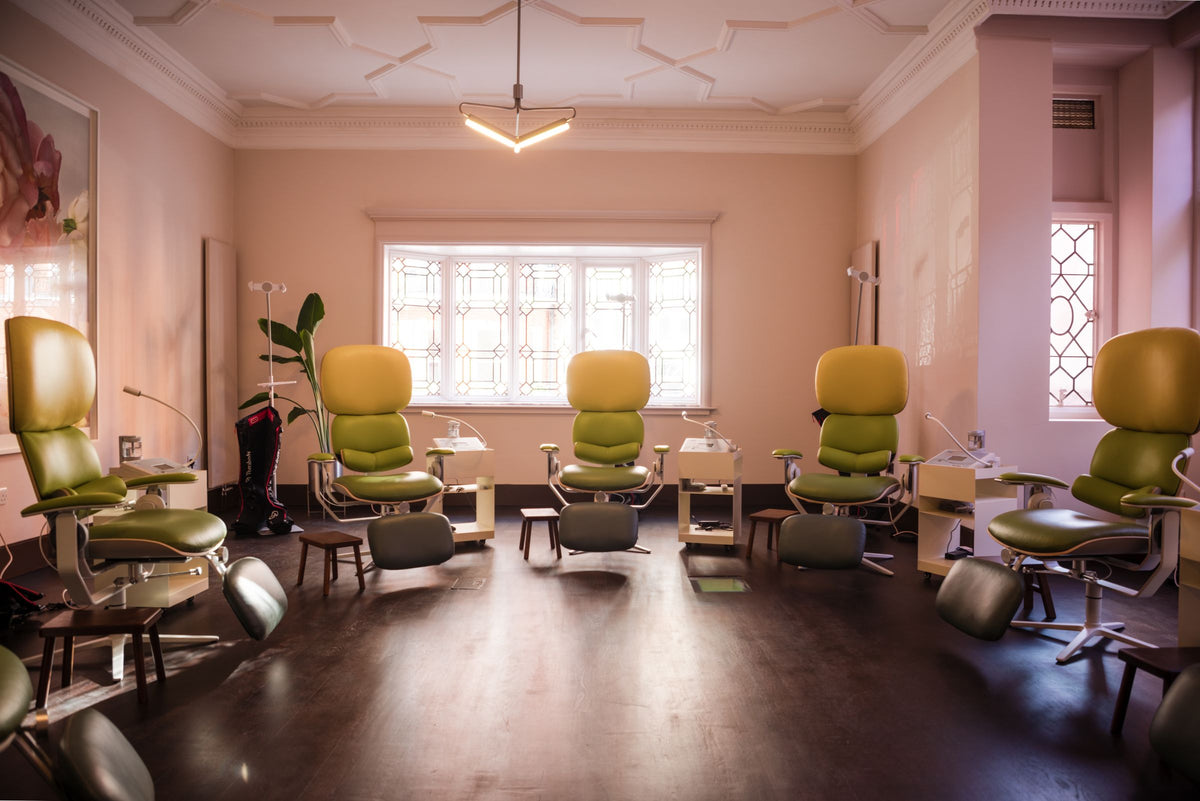 The recovery room at eyeam world: a row of green zero-gravity flotation chairs in a softly lit pink room